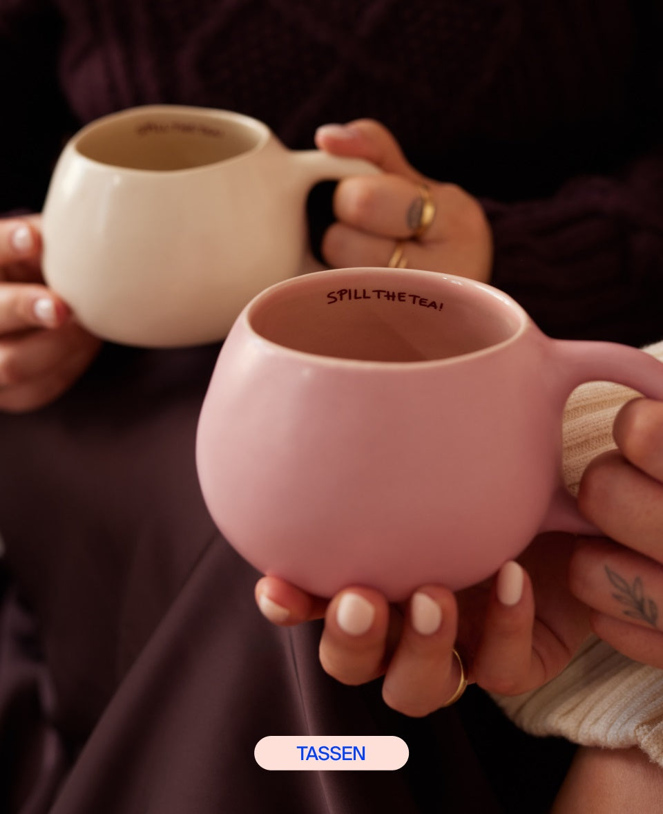 Zwei Personen halten pastellfarbene Tassen mit der Aufschrift "SPILL THE TEA!".