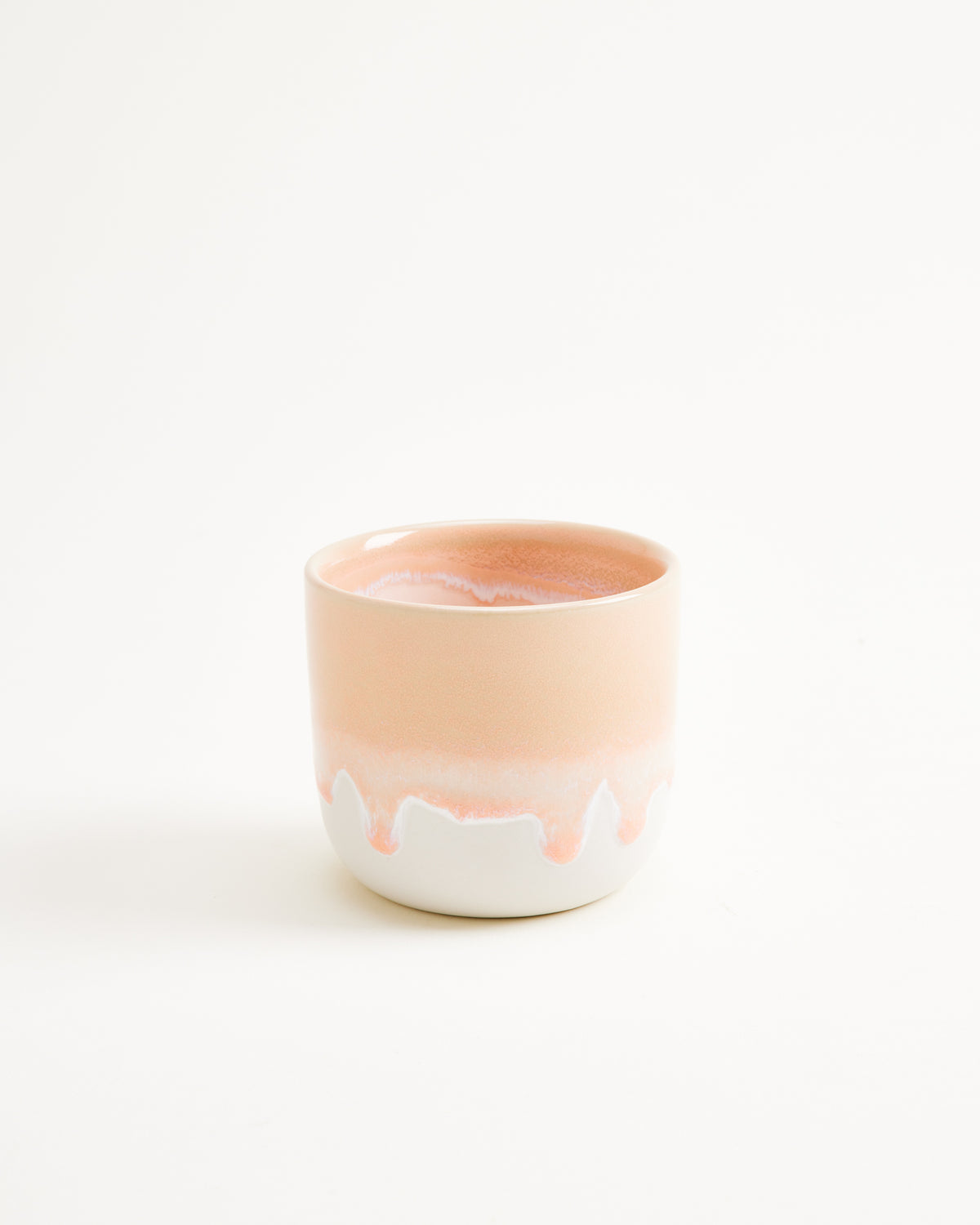 Keramikbecher mit rosa und weißem Verlauf auf weißem Hintergrund.