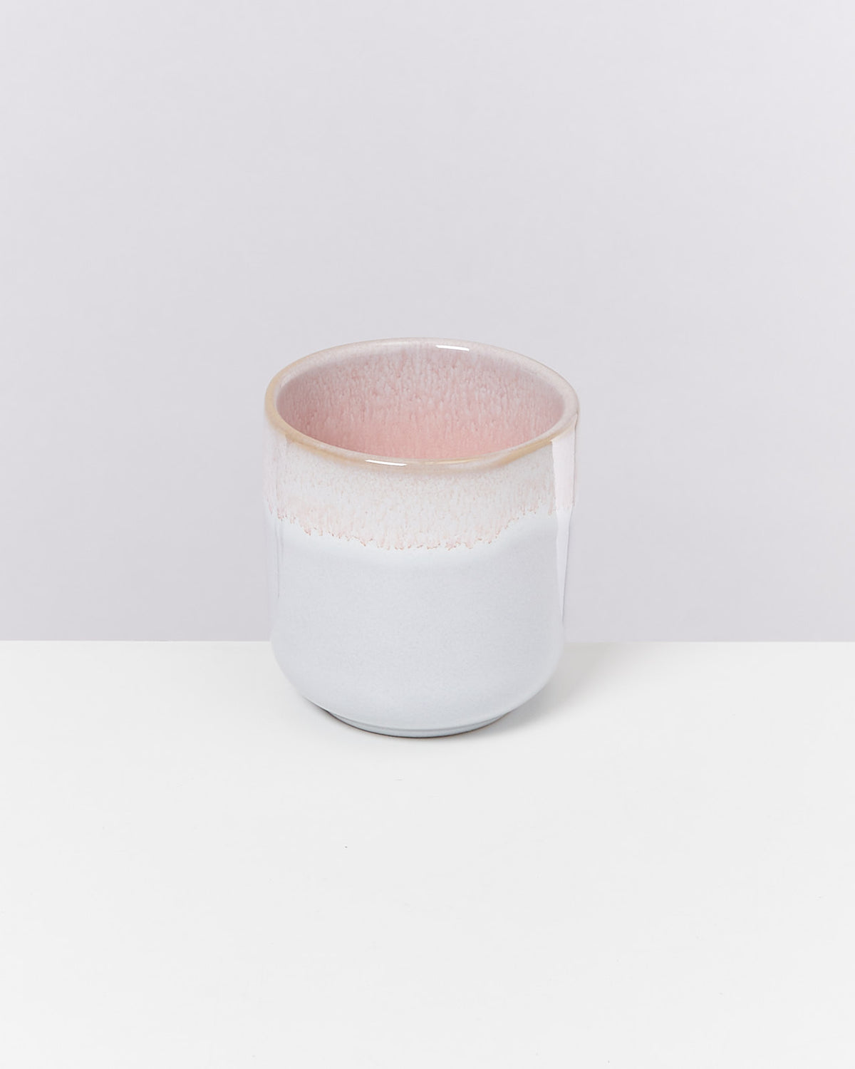 Keramikbecher in Pastelltönen auf weißem Hintergrund.