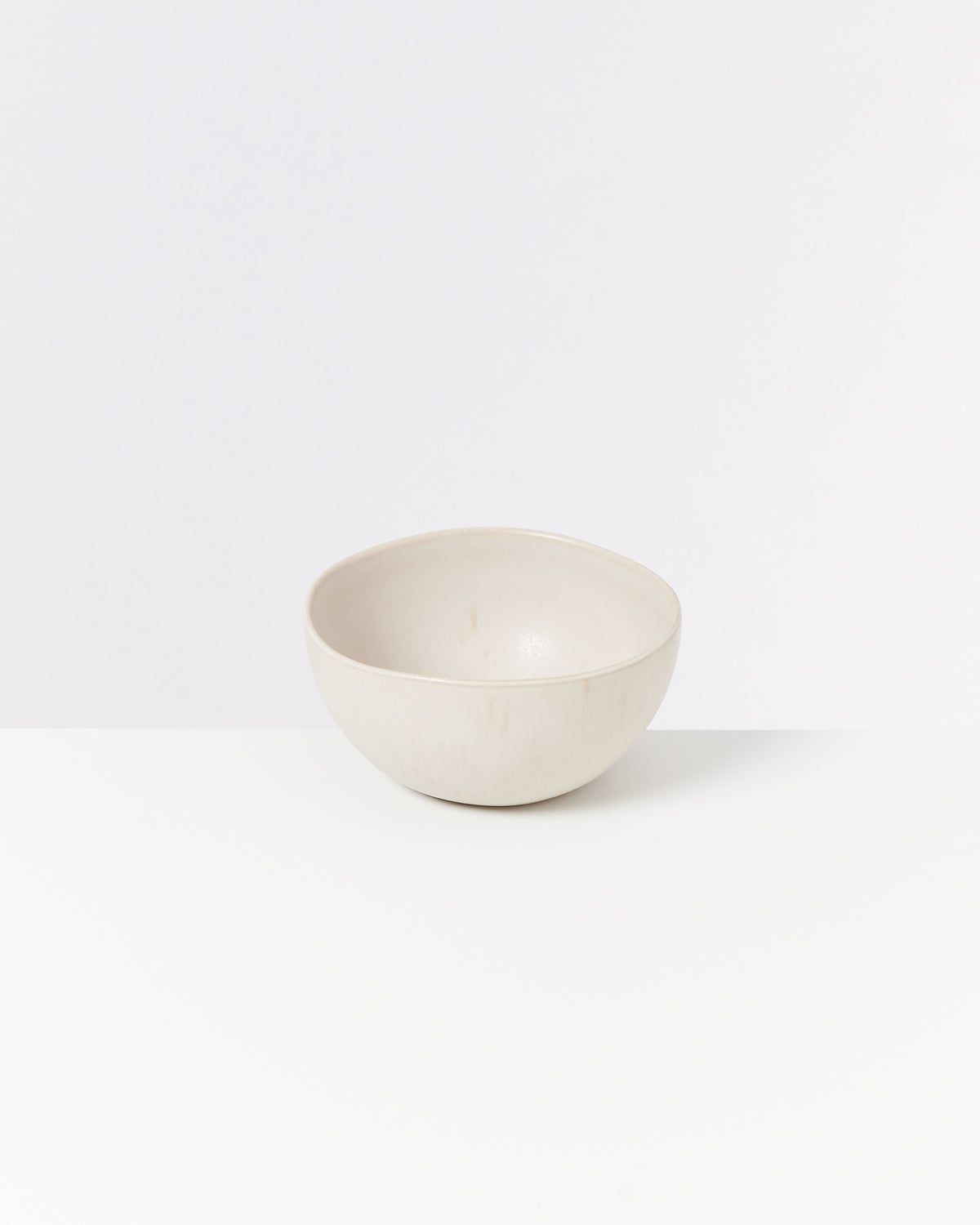 Beige Keramikschüssel auf weißem Hintergrund.