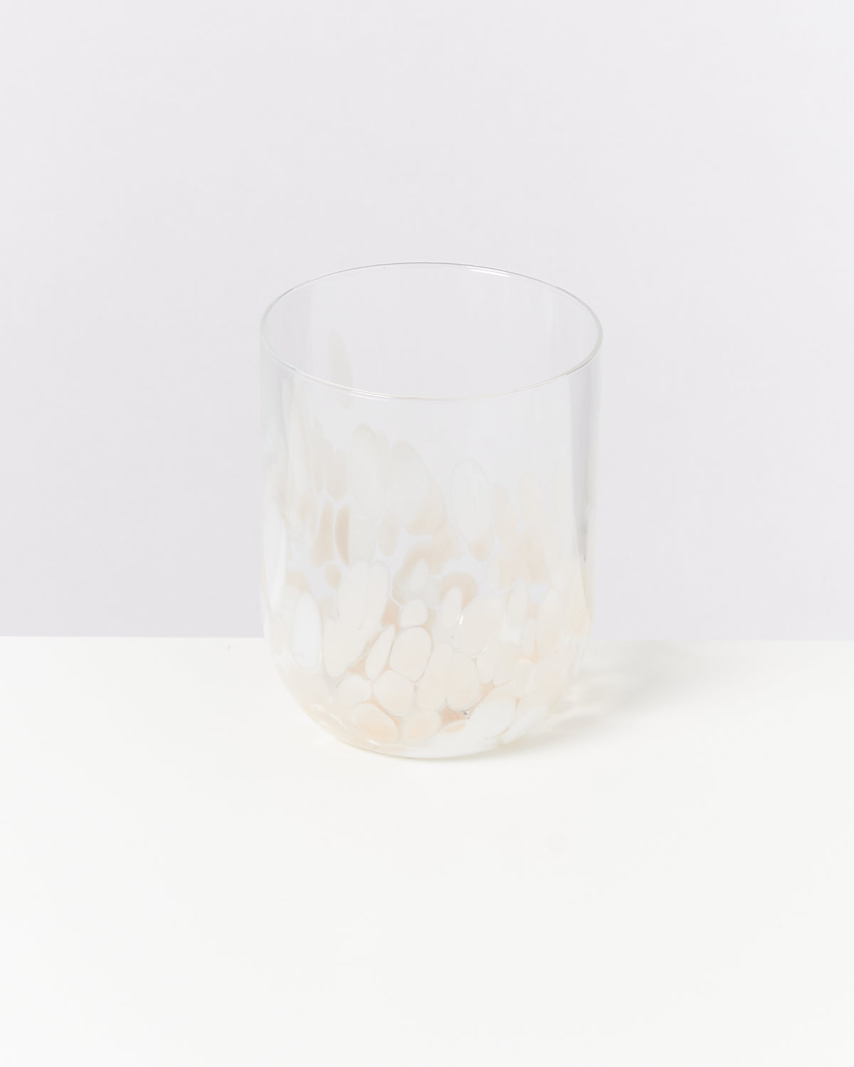 Durchsichtiges Glas mit weißen, marmorierten Mustern auf weißem Hintergrund.