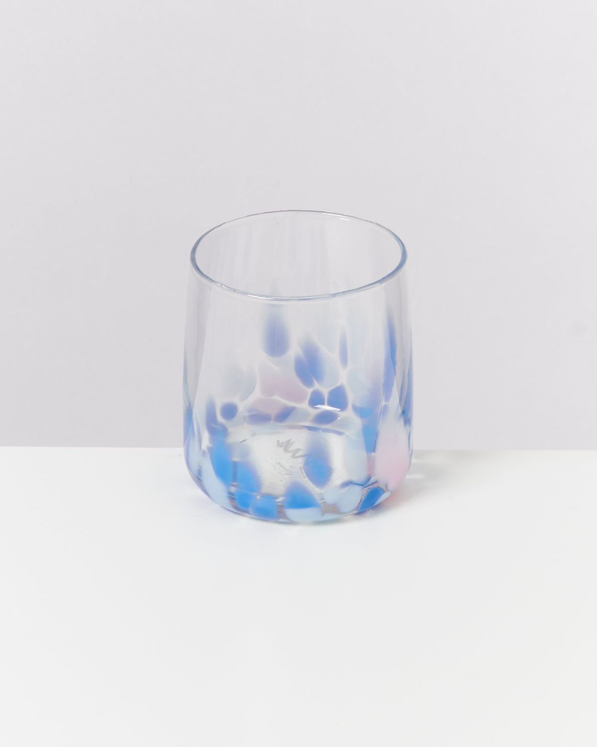 Ein Glas mit blauen und violetten Mustern auf weißem Hintergrund.
