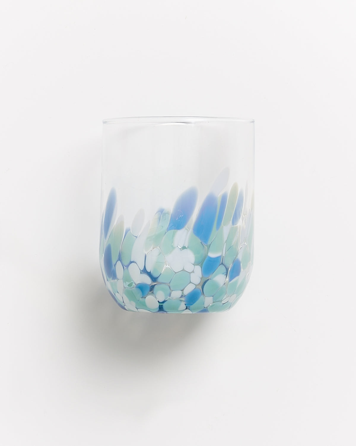 Ein transparentes Glas mit blau-grünen und weißen Mustern auf der unteren Hälfte vor weißem Hintergrund.