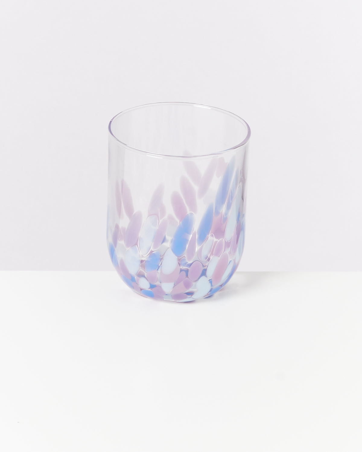 Transparenter Trinkbecher mit lila und blauen tupfenartigen Mustern auf weißem Hintergrund.
