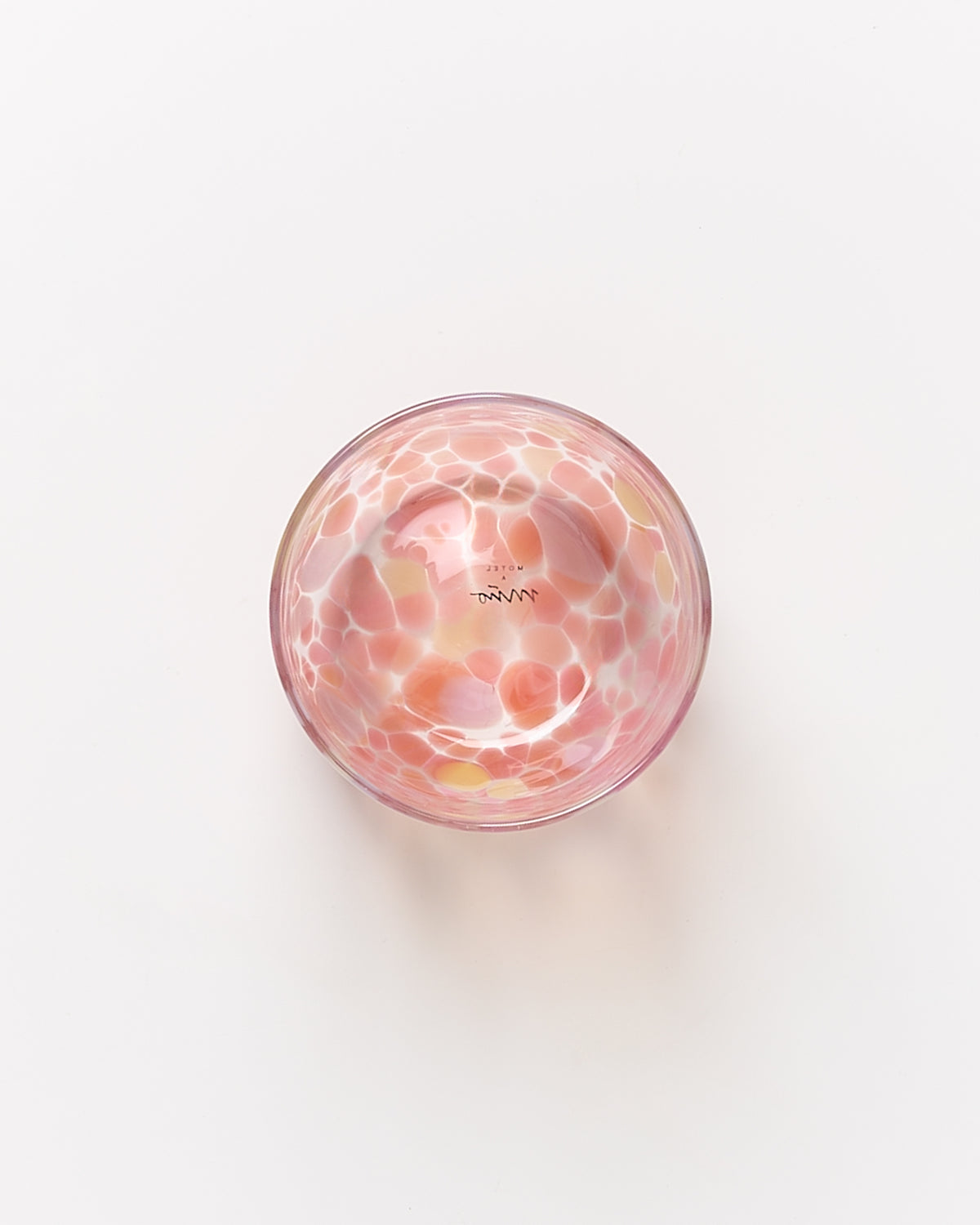 Runde Glasschale mit rosa und gelben Mustern auf weißem Hintergrund.