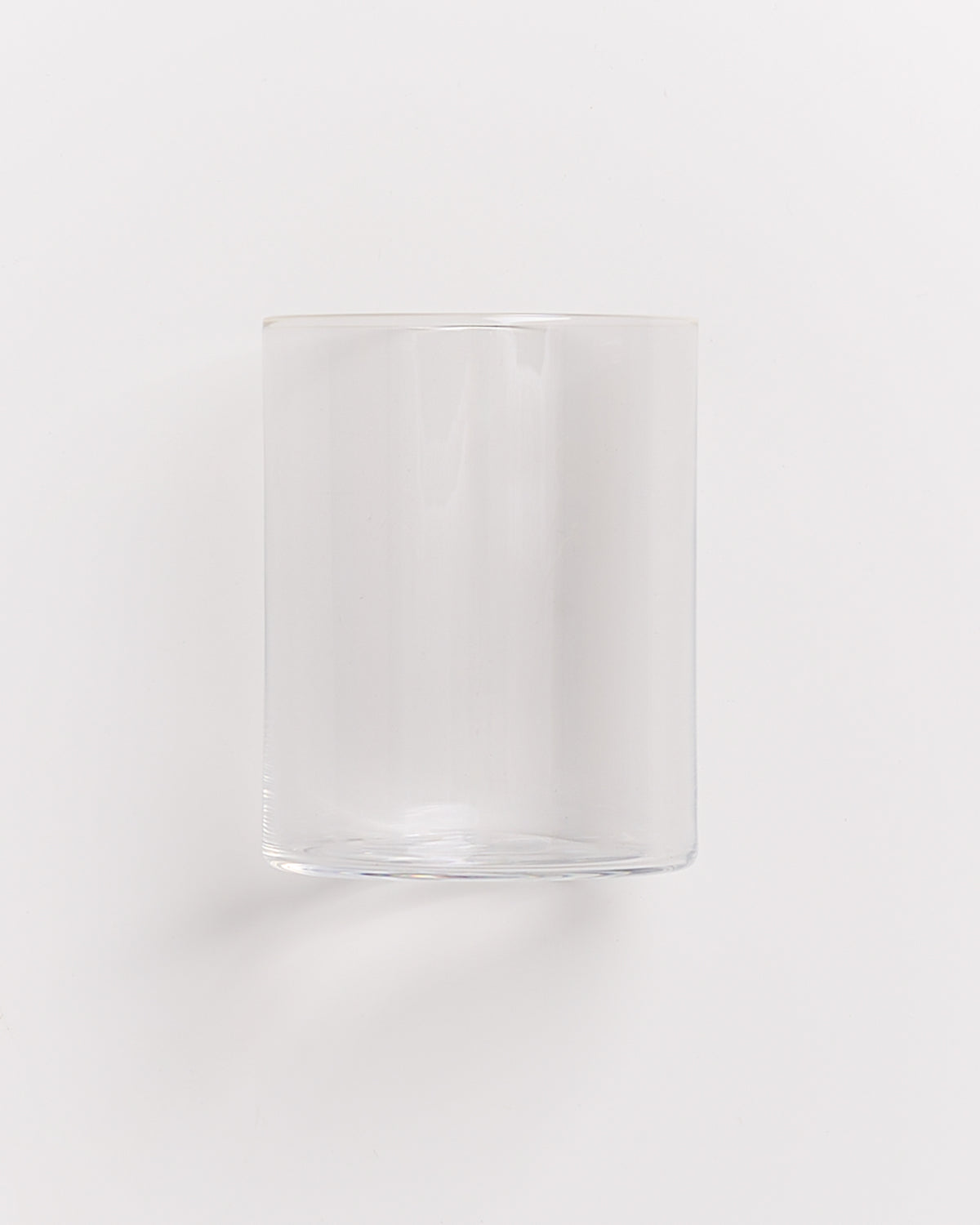 Ein leerer, durchsichtiger Glaszylinder vor weißem Hintergrund.