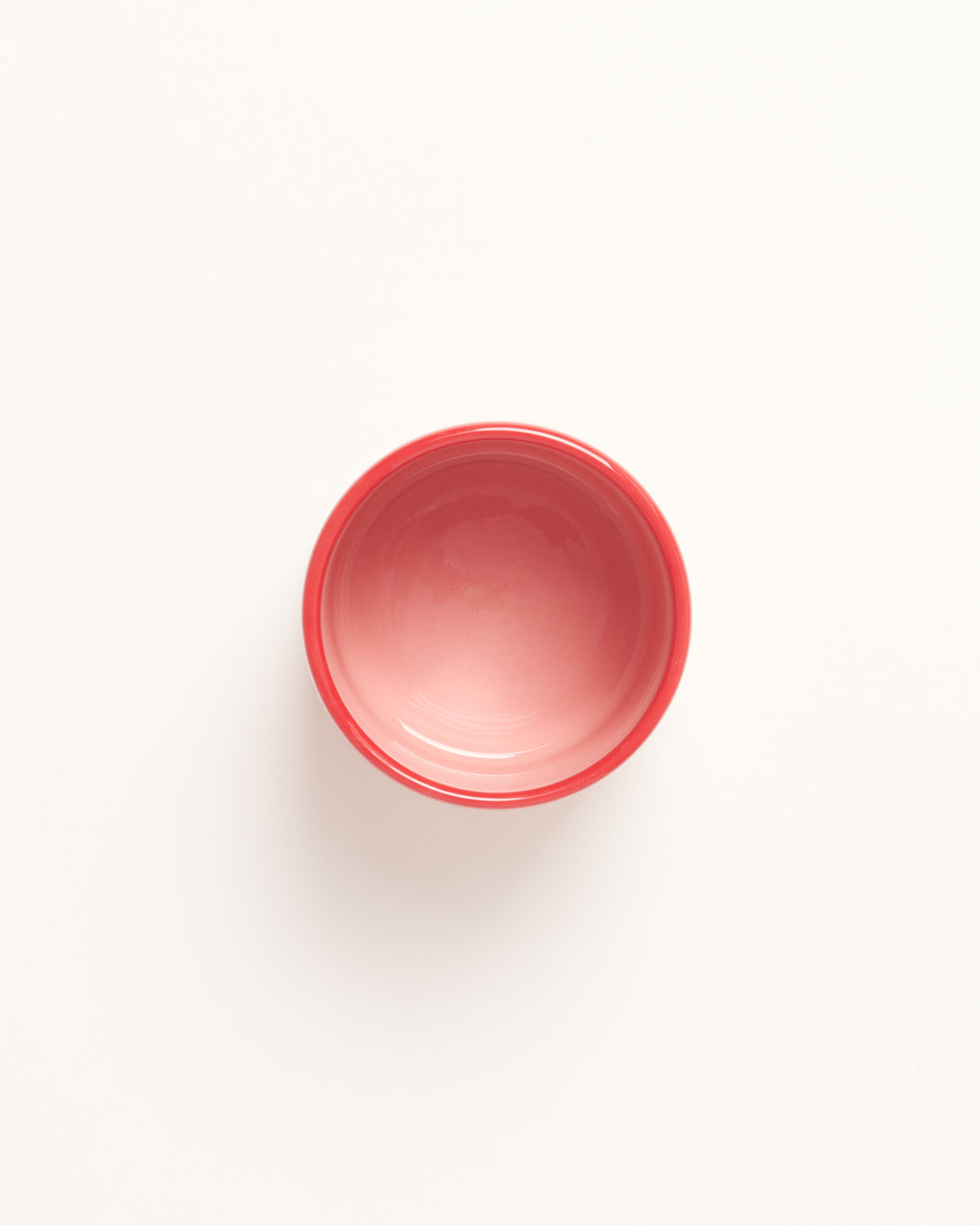 Rote Schale mit schlichtem Design auf weißem Hintergrund.