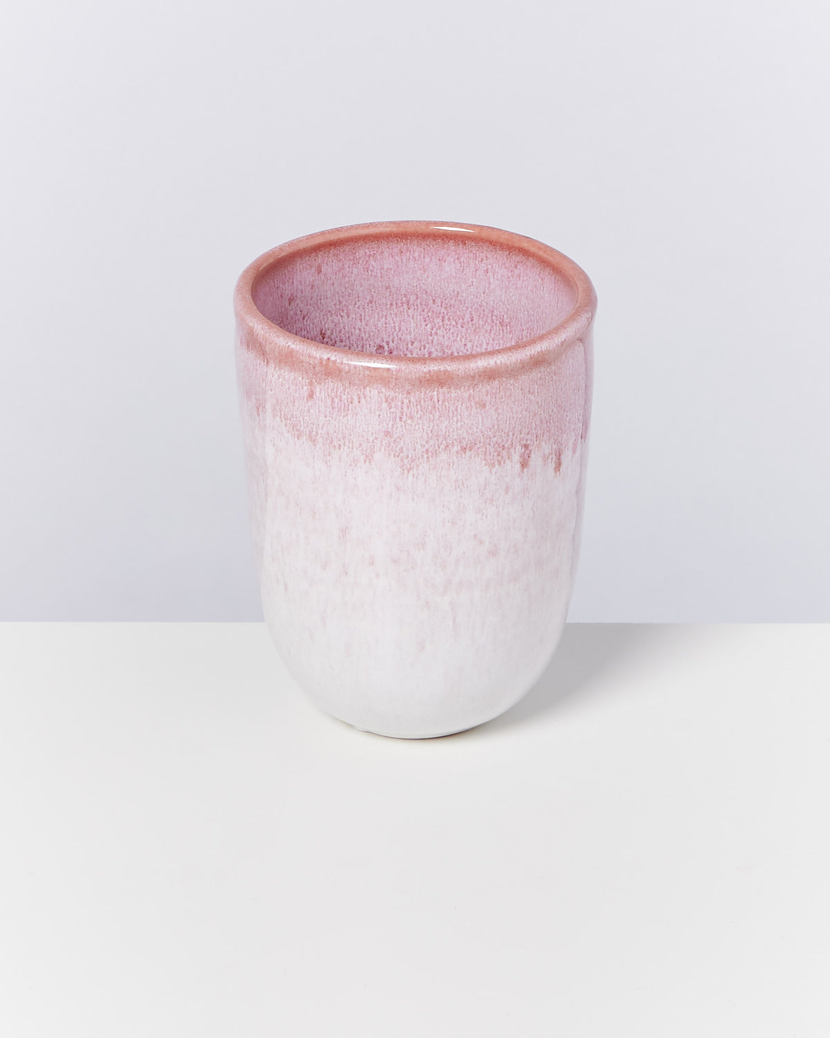 Keramiktasse mit rosa Verlauf auf weißem Untergrund.